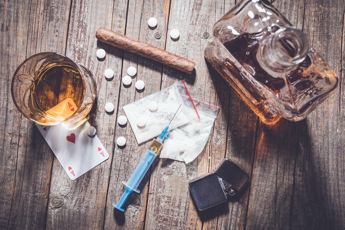 Hard drugs and alcohol on an old wooden table